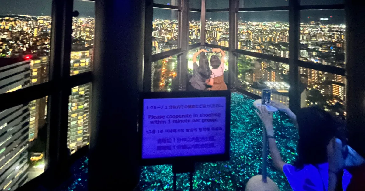 福岡タワー展望室から眺める街の夜景。撮影は手短にと呼びかける案内板も