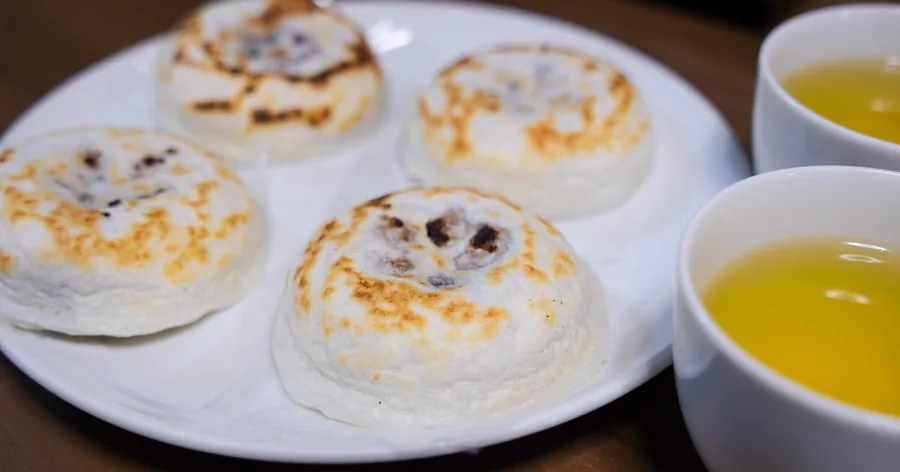 緑茶2杯と一緒に皿にのった、焼きたての梅ヶ枝餅
