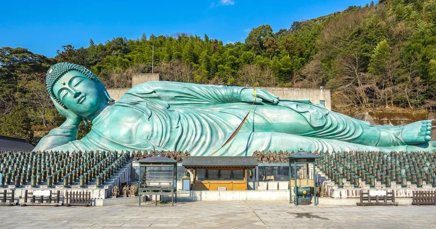 小さな石仏の列の上に横たわる、南蔵院の巨大なブロンズの涅槃像